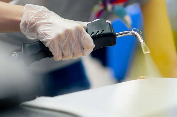 close up professional dry cleaning young girl bleaches stain on a white jacket professional equipment